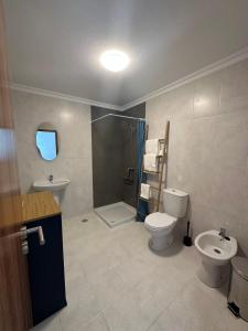 een badkamer met een toilet, een wastafel en een douche bij Estrela Villas in Estrela