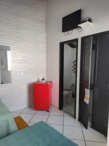 a bedroom with a red cabinet and a tv on the wall at suites com piscina praia dos anjos in Arraial do Cabo +14 photos