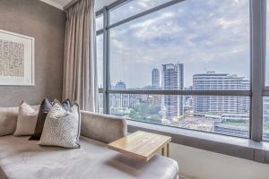 a living room with a couch and a large window at Masingita Towers Premium Hotel in Johannesburg