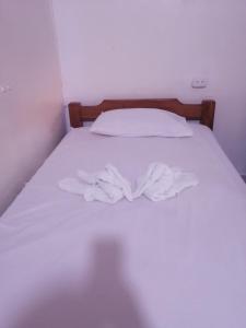 Una cama con sábanas blancas y dos toallas. en CABAÑAS DONDE EL PAISA, vista al mar, acceso a la playa, en Arboletes