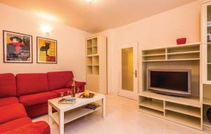 a living room with a red couch and a tv at Apartments with parking space Crikvenica - 14631 in Crikvenica