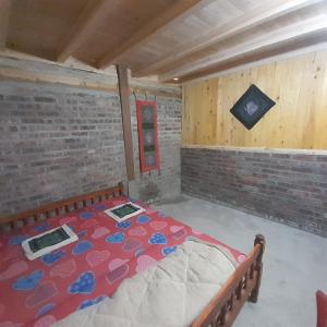 um quarto com uma cama numa parede de tijolos em Tee Homestay hmong and trekking em Lao Cai