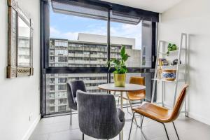 a dining room with a table and chairs and a large window at Experience Elegance at a Resort-style Urban Oasis in Melbourne