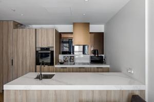 a kitchen with a sink and a counter top at The Claremont - Refined Resort Style Living in Melbourne