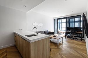 una cucina con lavello e un soggiorno di The Claremont - Refined Resort Style Living a Melbourne Altre 10 foto