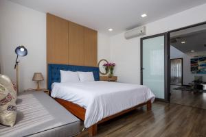 ダナンにあるLuxury Beach Villa Da Nangのベッドルーム(大きな白いベッド1台、ソファ付)