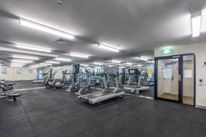 a gym with several treadmills and machines in it at Little Lonsdale Loft - Primely Located in the CBD in Melbourne