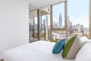 1 dormitorio con cama blanca y vistas a la ciudad en Skyhigh's Edge - City View Serenity by St Kilda Rd, en Melbourne