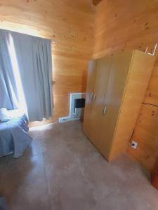 ein Schlafzimmer mit einem Bett und einem großen Fenster in der Unterkunft Brisa de Patagonia- Maiten in Trevelín