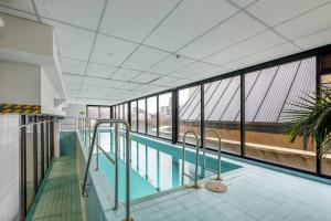 a large swimming pool in a building with windows at Little Lonsdale Loft - Primely Located in the CBD in Melbourne
