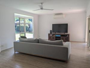 sala de estar con sofá y TV de pantalla plana en One bedroom in Mount Sheridan, en White Rock