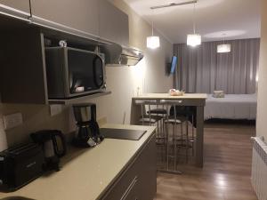 a small kitchen with a counter top and a room with a bed at Apart 312 Casa de Playa in Necochea
