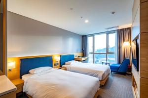 a hotel room with two beds and a window at Centum Business Hotel in Busan