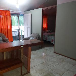 een kamer met een tafel en een slaapkamer met een bed bij Departamento Minae in Puerto Jiménez