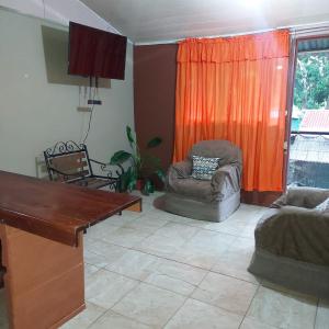 een woonkamer met een bank en een stoel bij Departamento Minae in Puerto Jiménez