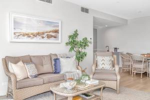 a living room with a couch and a table and chairs at Hamptons-inspired Waterfront Living on Moana Beach in Moana