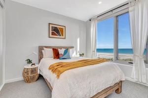 1 dormitorio con 1 cama y vistas al océano en Hamptons-inspired Waterfront Living on Moana Beach, en Moana