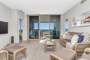 uma sala de estar com um sofá e uma mesa em Hamptons-inspired Waterfront Living on Moana Beach em Moana