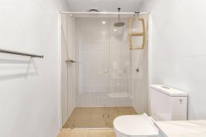 un bagno bianco con doccia e WC di Hamptons-inspired Waterfront Living on Moana Beach a Adelaide Altre 13 foto