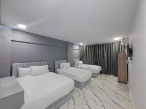 une chambre d'hôtel avec deux lits et un canapé dans l'établissement NADA _ HOTEL, au Caire
