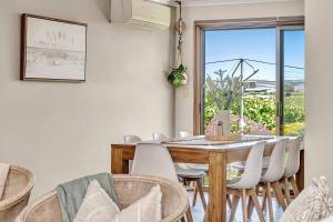 ein Esszimmer mit Tisch und Stühlen und einem Fenster in der Unterkunft Oliver's Homestead - An Idyllic Vineyard Retreat in McLaren Vale + 25 Fotos