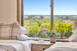 ein Schlafzimmer mit zwei Betten und einem großen Fenster in der Unterkunft Oliver's Homestead - An Idyllic Vineyard Retreat in McLaren Vale