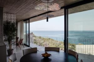 a dining room with a view of the ocean at Mare e Pietra -Pietra Luxury Villa Pefkali in Pefkali