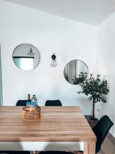 uma sala de jantar com uma mesa de madeira e 2 espelhos em Casa Dom Simões em Aljezur