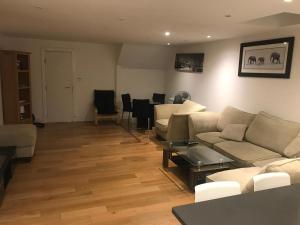 un soggiorno con divani, tavolo e sedie di Southgate 5 bedroom property a East Barnet