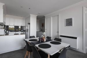 - une cuisine et une salle à manger avec une table et des chaises dans l'établissement Grand Luxury in the CBD along the Yarra River, à Melbourne