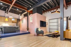 an open living room and kitchen in an industrial building at Fitzroy Thrills in MacRobertson Factory Conversion in Melbourne
