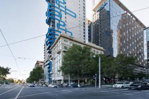 une rue de la ville avec des voitures garées devant de grands bâtiments dans l'établissement Grand Luxury in the CBD along the Yarra River, à Melbourne