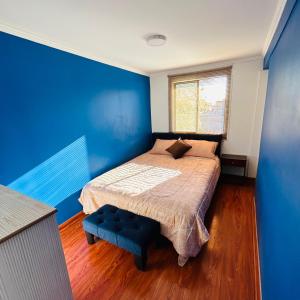 Dormitorio azul con cama y pared azul en LUXURY STAY, en Santiago