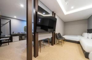 um quarto com uma cama e uma televisão num quarto em Hotel Harbor em Tongyeong