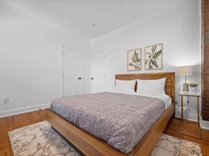 1 dormitorio con cama y pared blanca en Shadyside, Pittsburgh, Modern and Cozy 1 Bedroom Unit3 with Free Parking en Pittsburgh