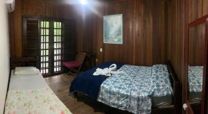 ein Schlafzimmer mit einem Bett mit einer weißen Schleife darauf in der Unterkunft Pousada D'Aconchego Nova Brasilia in Ilha do Mel