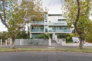 a white building with trees in front of it at Elster's Edge - A Stylish Elwood Escape with Terrace in Melbourne