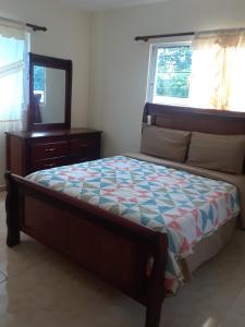 1 dormitorio con cama, tocador y espejo en Coco Resort Samana en Santa Bárbara de Samaná