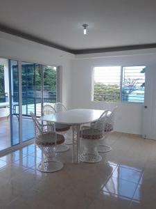 comedor con mesa blanca y sillas en Coco Resort Samana en Santa Bárbara de Samaná