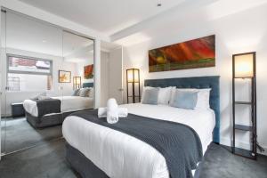 een slaapkamer met een groot bed en een bank bij Elster's Edge - A Stylish Elwood Escape with Terrace in Melbourne