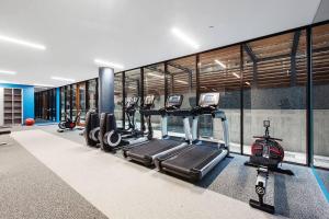 a gym with a row of treadms and cardio machines at Top of Town - Penthouse with Every Opulence in Melbourne
