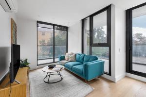 un soggiorno con divano blu e tavolo di Executive Resort-Style Living at Leafy Albert Park a Melbourne
