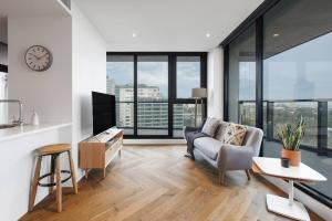 sala de estar con sofá y TV en Lakeside Five Star Luxury with Uninterrupted Views en Melbourne