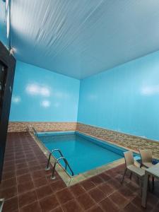 a swimming pool in a room with blue walls at شاليهات ستي لاند in Taif