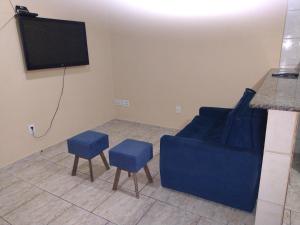 een woonkamer met een blauwe bank en twee blauwe krukken bij Casa de Praia completa em Cabo Frio 6 para até 5 pessoas in Cabo Frio