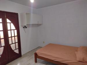 a bedroom with a bed and a cabinet and a window at Casa de Praia completa em Cabo Frio 6 para até 5 pessoas in Cabo Frio