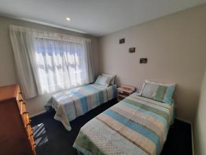 um quarto com 2 camas e uma janela em Colour on Cairnmuir em Wanaka