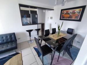 a dining room with a table and black chairs at Departamento de 2 dormitorios y 1 baño in Arica