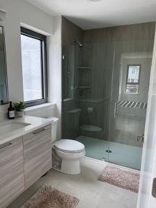 a bathroom with a toilet and a glass shower at Luxury Furnished Apartment in Heart of Quincy in Quincy
