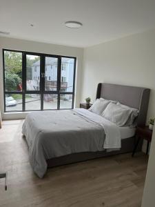 um quarto com uma cama grande e uma janela grande em Luxury Furnished Apartment in Heart of Quincy em Quincy